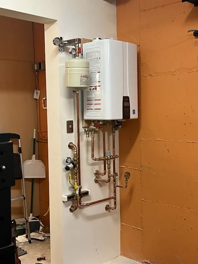 Plumbing technician inspecting water heater connections in Westminster